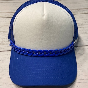 May include: A blue and white trucker hat with a blue chain detail across the brim. The hat features a white front panel, a blue brim, and a blue mesh back. The chain is a vibrant blue color.