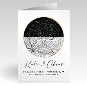 May include: A folded white card featuring a black and white design. The top half displays a star map, while the bottom half shows a detailed map. The card includes the names "Katie & Chris" and location details.