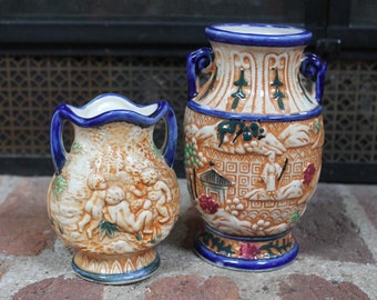 2 jarrones japoneses de mayólica con dos asas, estilo urna, de cerámica artística con escenas tradicionales de Japón y querubines, cerámica vidriada.