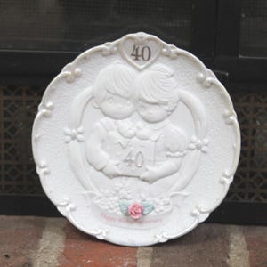 May include: A set of three ceramic mugs with a speckled, matte finish. The mugs are in shades of cream, light gray, and dark gray. Each mug has a simple, minimalist design and a rounded handle. The mugs are stacked on top of each other.