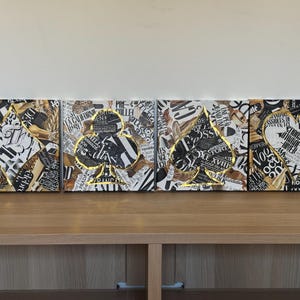 May include: Four square canvases with a collage of black and white text and gold accents. Each canvas features a large black and white image of a playing card, the suit of clubs.