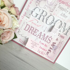 May include: A pink and gray wedding card with the word "Groom" in large, stylized letters. The card has a grid pattern with various words and phrases, including "Trust", "Dreams", "From this day forward", "Best Friends for life, Husband & Wife", and "Happily Ever After".