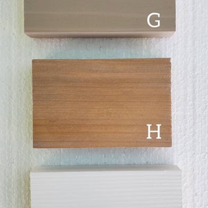 May include: Three wood samples, labeled G, H, and I. The sample labeled G is a light brown color, the sample labeled H is a medium brown color, and the sample labeled I is white.