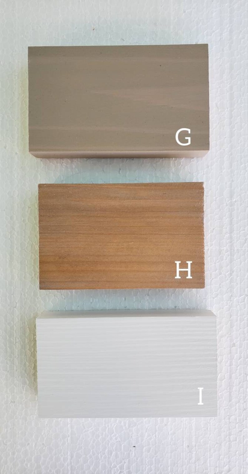 May include: Three wood samples, labeled G, H, and I. The sample labeled G is a light brown color, the sample labeled H is a medium brown color, and the sample labeled I is white.