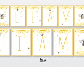 May include: A yellow and white banner with the name "LIAM" spelled out in gold letters. Each letter is on a separate flag with a honeycomb pattern and a small bee illustration.