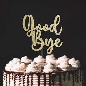 Op de afbeelding: Een chocoladetaart met witte frosting en een gouden glitter 'Good Bye' taarttopper.