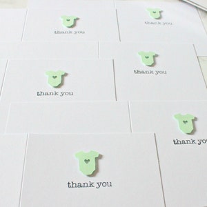 May include: Set of thank you cards with a green baby onesie cutout and the text "thank you" on each card.