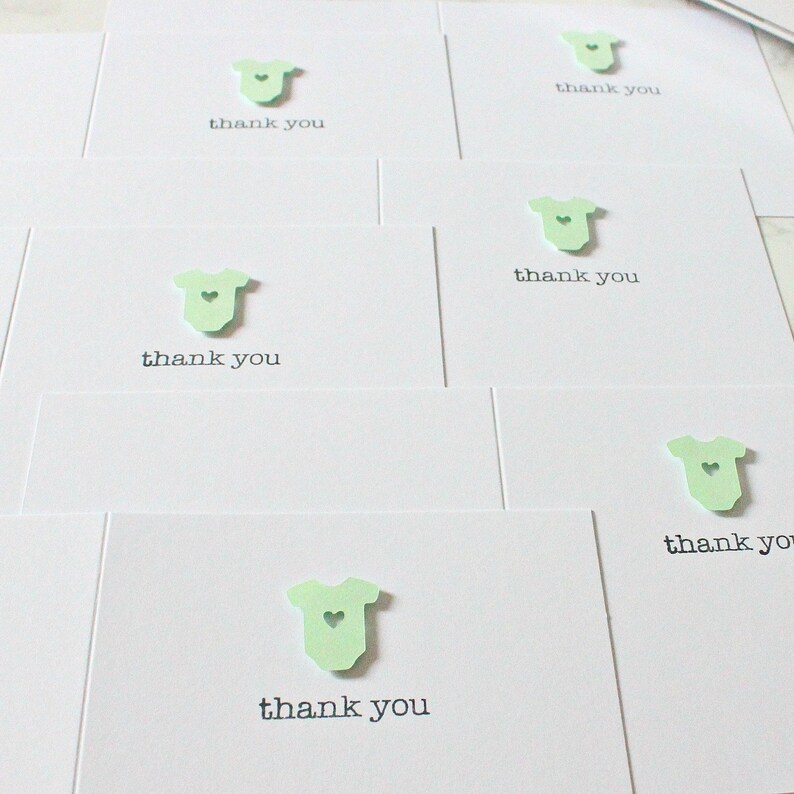 May include: Set of thank you cards with a green baby onesie cutout and the text "thank you" on each card.