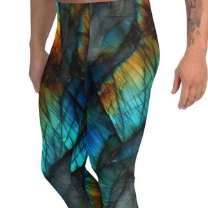 May include: Vibrant leggings with a unique pattern in shades of blue, teal, and gold. The leggings have a form-fitting design and are made of a comfortable material. The leggings are paired with white sneakers.