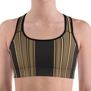 May include: Black and gold striped sports bra with a scoop neck and racerback design. The bra features vertical gold stripes on a black background, with black trim around the neckline and straps. The sports bra is designed for athletic activities.