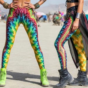 May include: Three people wearing colorful tie-dye leggings and tops. The leggings feature a vibrant rainbow pattern. The outfits are accessorized with jewelry and boots. The image has the text "7BYTE CLOTHING" at the top.