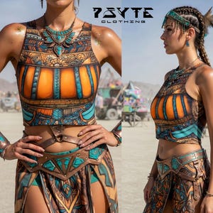 May include: A two-piece outfit with a tank top and skirt, featuring an intricate pattern in orange, teal, and brown. The outfit includes a matching belt and jewelry. The brand name "PSYTE CLOTHING" is visible in the image.