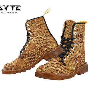 Könnte beinhalten: Ein Paar braune Lederstiefel mit einem schuppigen Muster. Die Stiefel haben schwarze Schnürsenkel und eine gelbe Lasche.