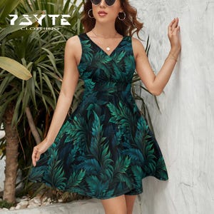May include: A sleeveless, V-neck dress with a vibrant green and black leaf pattern. The dress features a fitted bodice and a flared skirt. The brand name "7SYTE CLOTHING" is visible in the upper left corner.