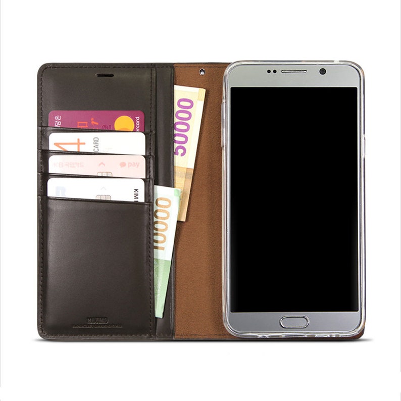 May include: A brown leather phone case with a built-in wallet. The case has slots for credit cards and a pocket for cash. The phone case is open and a smartphone is visible inside.