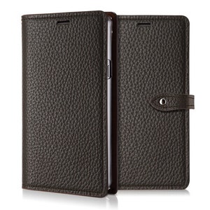 May include: A dark brown leather phone case with a flap that closes with a snap. The case has a textured surface and a small metal button on the flap.