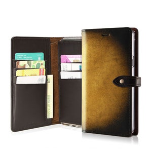 May include: A brown leather wallet case with a gold-toned front flap. The case has multiple card slots and a money pocket. The case is open to reveal a phone holder.