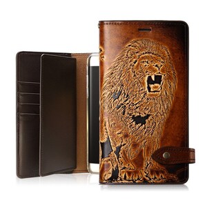 May include: Brown leather phone case featuring an embossed lion design. The case opens to reveal card slots and a phone holder. A magnetic clasp secures the case. The phone case is designed to protect the phone.