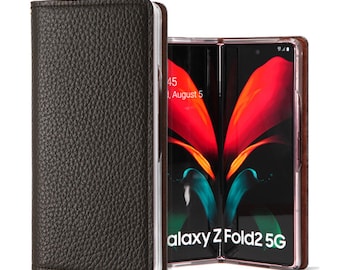 Puede incluir: Una funda de teléfono de cuero negro con un teléfono Samsung Galaxy Z Fold2 5G en su interior. El teléfono está abierto y la pantalla muestra la hora y la fecha.