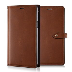 May include: A brown leather phone case with a flap that folds over the front of the phone. The case has a strap with a metal button on the right side.