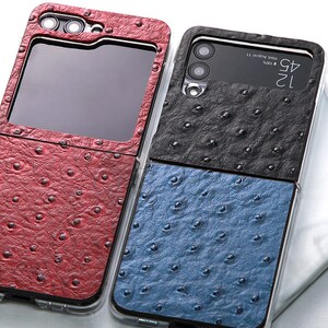 May include: Two phone cases with a faux ostrich skin pattern. The case on the left is red and the case on the right is black and blue. The case on the right has the text "12 4G" and "Wed August 11" on the back.