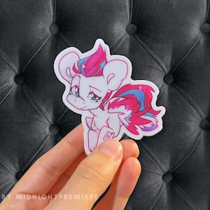 Könnte beinhalten: Ein Aufkleber mit einem Cartoon-Pony mit rosa und blauen Haaren und Flügeln. Das Pony hat einen weißen Körper und blaue Augen. Der Aufkleber befindet sich auf einem grauen Hintergrund.