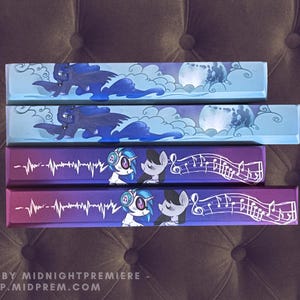 May include: Four rectangular items with colorful illustrations. Two feature a dark blue pony with wings and a moon, set against a light blue background. The other two have pony characters with headphones and musical notes on a purple background.