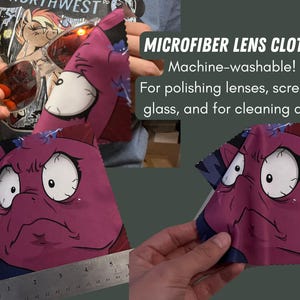 May include: Two microfiber lens cloths with a cartoon character design. The cloths are purple and blue with a white cartoon character with large eyes and a frown. The text "MICROFIBER LENS CLOTHS" is written in black on a white background. The text "Machine-washable!" is written in black on a white background. The text "For polishing lenses, screens, glass, and for cleaning dust" is written in black on a white background.