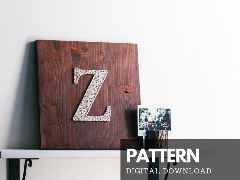 May include: A digital download pattern for string art featuring the letter Z. The pattern is displayed on a brown wooden board with white string wrapped around nails to form the letter.