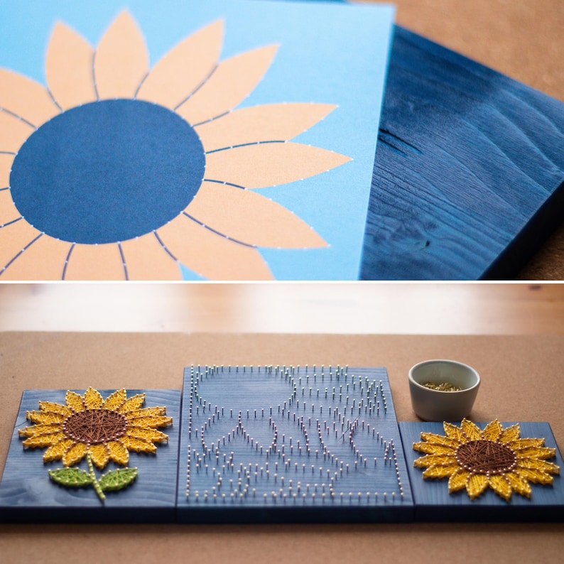 以下が含まれることがあります： 青い背景の3枚の木製板。中央の板は、ひまわりの形に釘が打たれています。両側の板は、糸で作ったひまわりです。