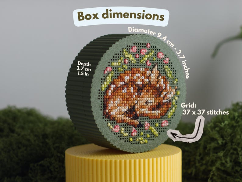 Round cross stitch box STL file dimensions — 9.4 cm diameter, 3.7 cm depth, 37×37 stitch count, shown with sleeping fawn embroidery on green PLA lid