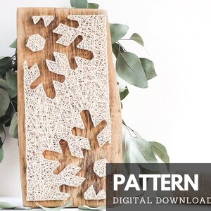 May include: A digital download pattern for a string art snowflake design. The pattern is displayed on a wooden board with white string wrapped around nails to create the snowflake shape. The pattern is perfect for creating a unique and festive wall hanging.