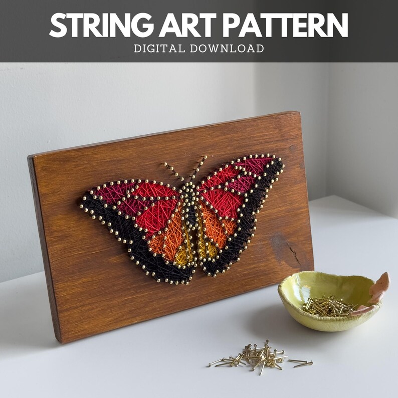 DIY butterfly string art finished using printable pattern – thread art sign on wooden board with brass nails and bowl on white desk