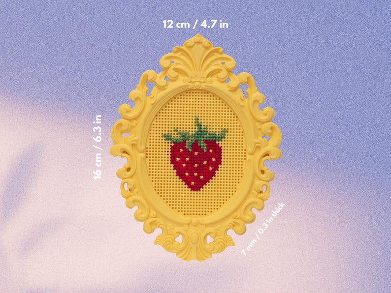 Yellow baroque oval cross stitch frame with a stitched strawberry design, labelled with dimensions 16 × 12 cm and 7 mm thick. Stitchable frame printed from the STL file.