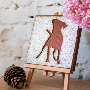Stress relief craft kit for adults with dog silhouette string art on stained wood base, calming DIY wall decor project.