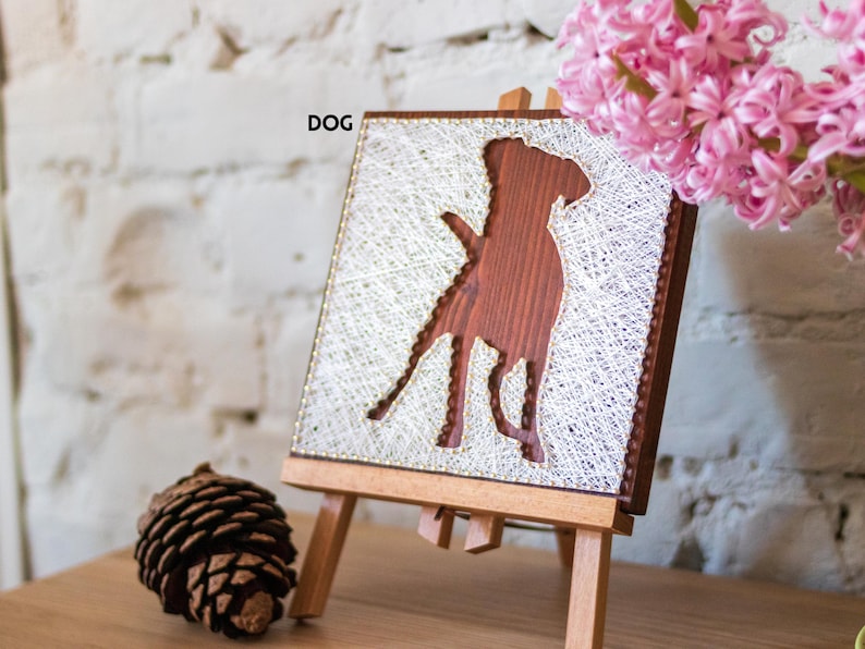 Stress relief craft kit for adults with dog silhouette string art on stained wood base, calming DIY wall decor project.