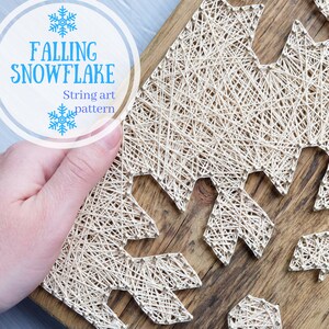 May include: String art pattern of a snowflake falling on a wooden background. The title "Falling Snowflake" and "String art pattern" are written in white text on a white circle with a blue snowflake.