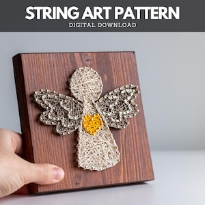 Può includere: Un'opera d'arte in filo di legno con un disegno di angelo. L'angelo è realizzato con filo di colore chiaro e ha un cuore giallo. La base in legno è tinta di marrone scuro. Il testo "STRING ART PATTERN DIGITAL DOWNLOAD" è in alto.
