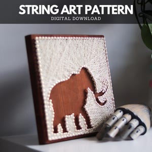 Könnte beinhalten: Ein Holz-String-Art-Stück mit einem Elefanten-Design. Der Elefant ist braun, vor einem Hintergrund aus weißem Faden. Der Text "STRING ART PATTERN DIGITAL DOWNLOAD" steht oben. Das Kunstwerk wird auf einer weißen Oberfläche präsentiert.