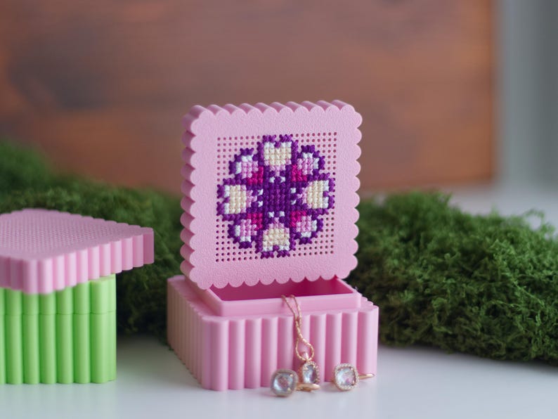 Open 3D printed pink cross stitch keepsake trinket box with purple flower embroidery on perforated lid, used as a jewellery boxOpen 3D printed pink cross stitch keepsake trinket box with purple flower embroidery on perforated lid, used as a jewellery box