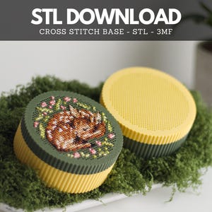 May include: Two round, 3D-printed containers with ribbed sides. One container is yellow with a yellow lid featuring a grid pattern. The other is yellow with a dark green lid featuring a cross-stitched fawn design with pink flowers.