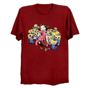 May include: Red t-shirt with a cartoon image of a girl with pink hair and a pink dress surrounded by yellow robots with blue legs.