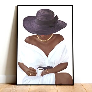 Puede incluir: Una mujer con una camisa blanca y un sombrero negro de ala ancha con una cinta negra se sienta con una taza blanca peque&ntilde;a en sus manos.