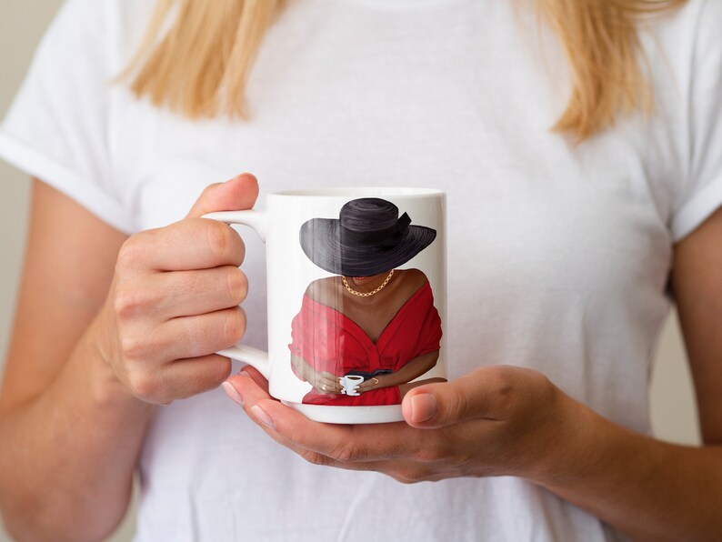 Puede incluir: Taza de cer&aacute;mica blanca con una ilustraci&oacute;n colorida de una mujer con un vestido rojo y un sombrero negro, sosteniendo una taza.