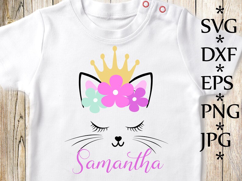 Puede incluir: Una camiseta blanca con un dise&ntilde;o de gato rosa y blanco que lleva una corona dorada y flores. El nombre Samantha est&aacute; escrito en rosa debajo del gato.