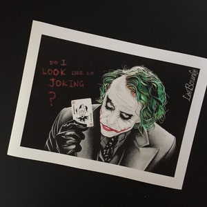 Op de afbeelding: Een zwart-witte tekening van de Joker uit de Batman-film. Hij houdt een speelkaart vast met een joker erop. De tekst "Do I look like I'm joking?" is in rood boven het hoofd van de Joker geschreven.