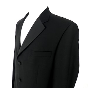 May include: A black tuxedo jacket with a shawl collar and two buttons. The jacket has a single pocket on the left side.