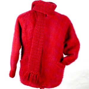May include: A red fuzzy cardigan with a matching red and purple scarf. The cardigan has two pockets and a button closure.
