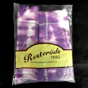 May include: A package of purple and white tie-dye fabric. The package has a label that says "Resteröds Trika Kvalitet av högsta klass sedan 1935."