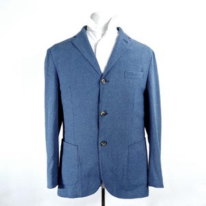 May include: A blue blazer with a textured fabric and three buttons. The blazer has two pockets on the front.